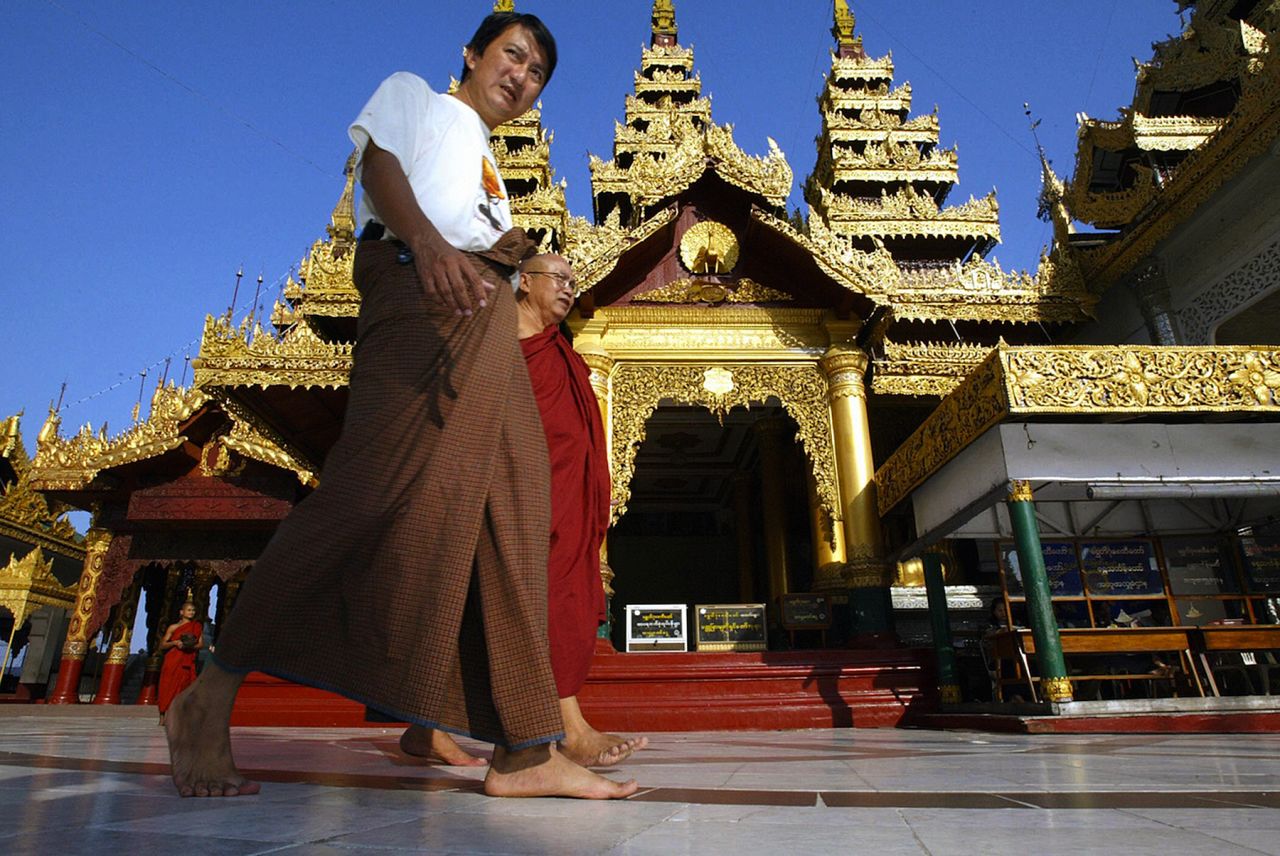The traditional Burmese dress is the longyi, a wraparound skirt worn by men and women. Men tie theirs in the front and women fold the cloth over and secure it at the side. Here, a longyi-clad visitor walks inside the Shwedagon Pagoda in Yangon.     