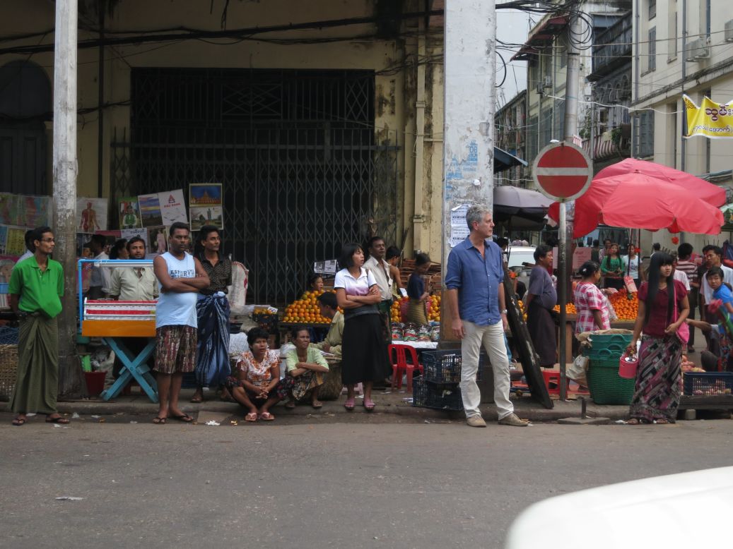 Anthony Bourdain waits for the bus during rush hour in Yangon.