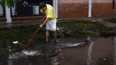 A man tries to drain water from a flooded street in La Plata on April 3.