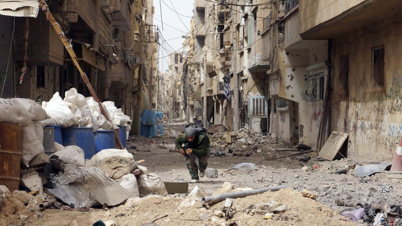 A Syrian rebel runs for cover in Deir ez-Zor on April 2.