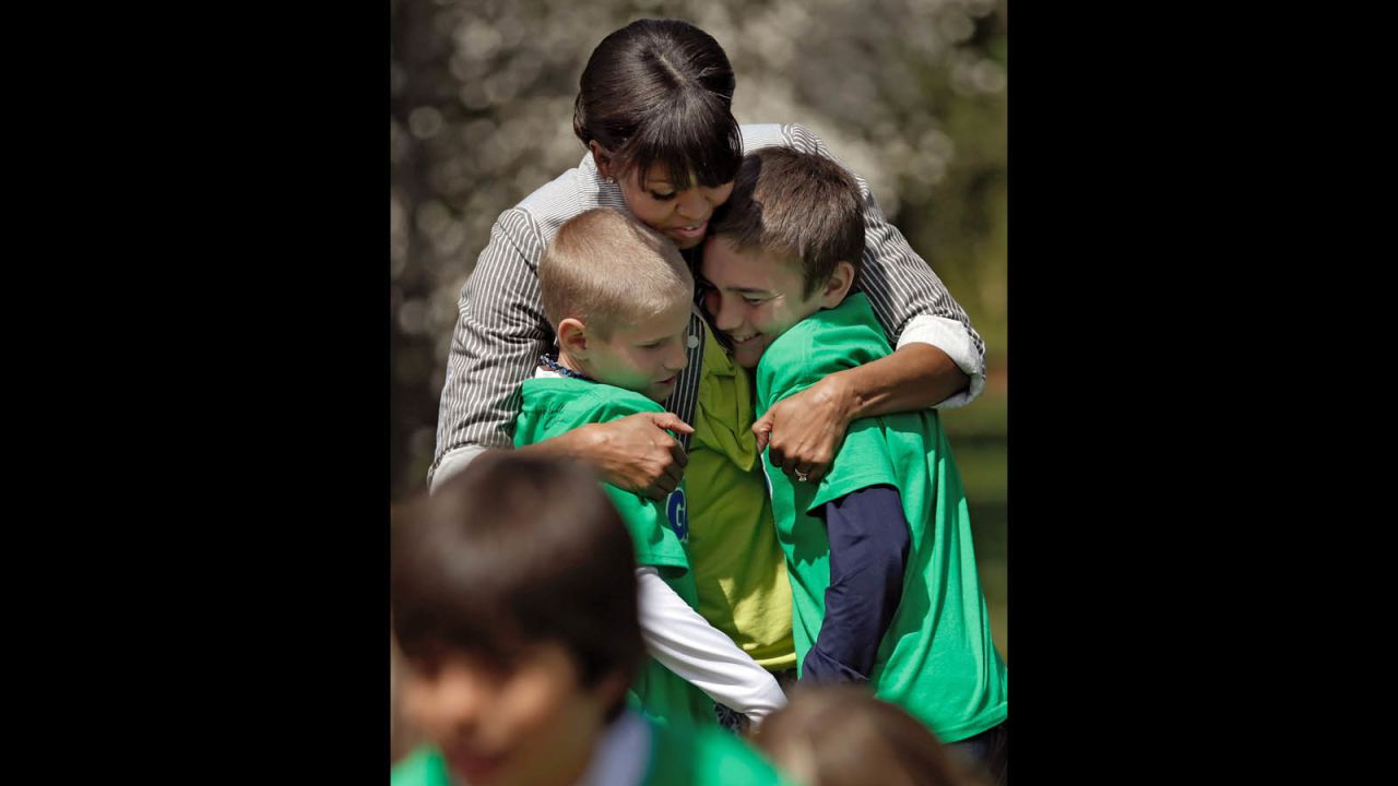 The first lady embraces two of her fellow gardeners.