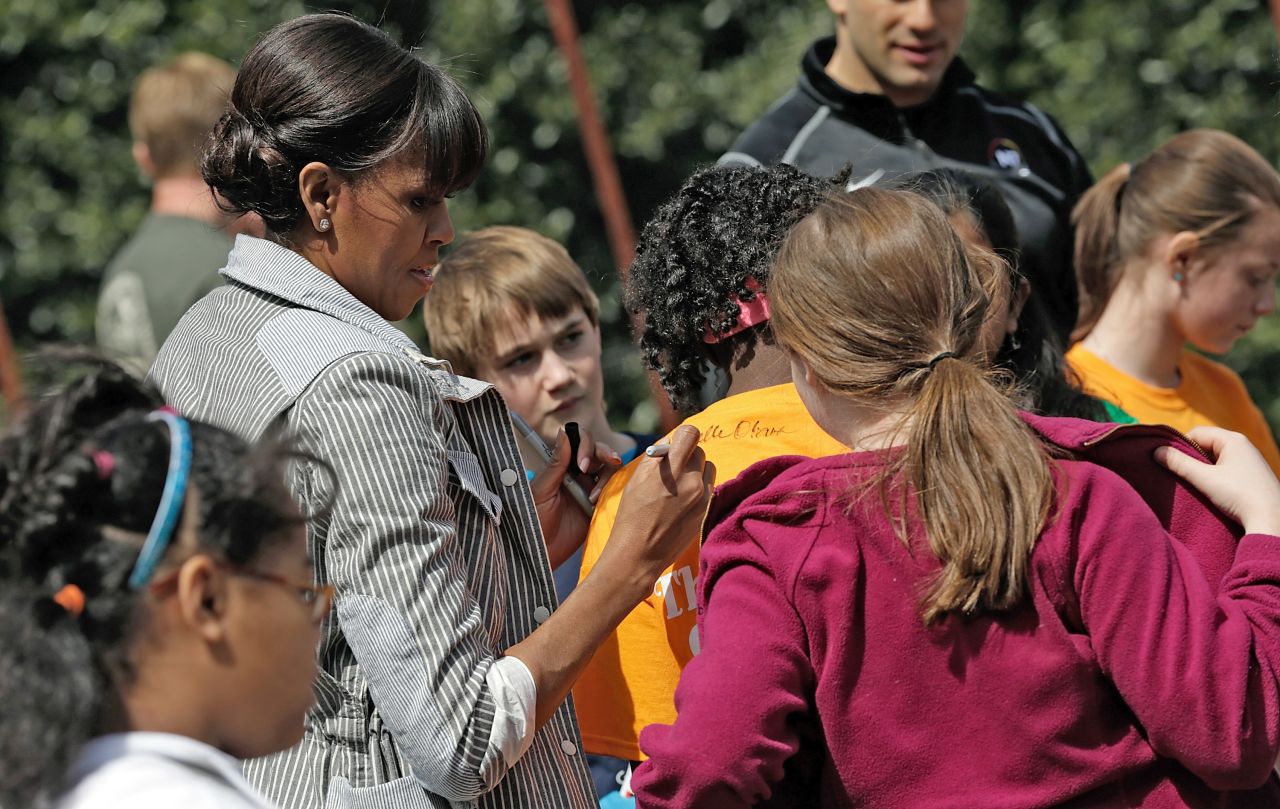 Obama signs a student's shirt.