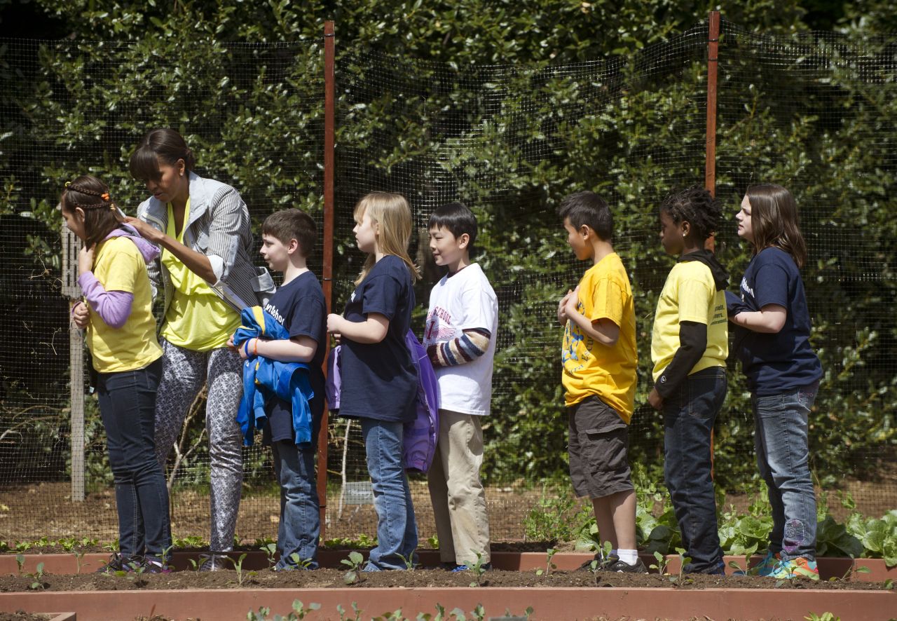 The students line up to get the first lady's autograph on their shirts.