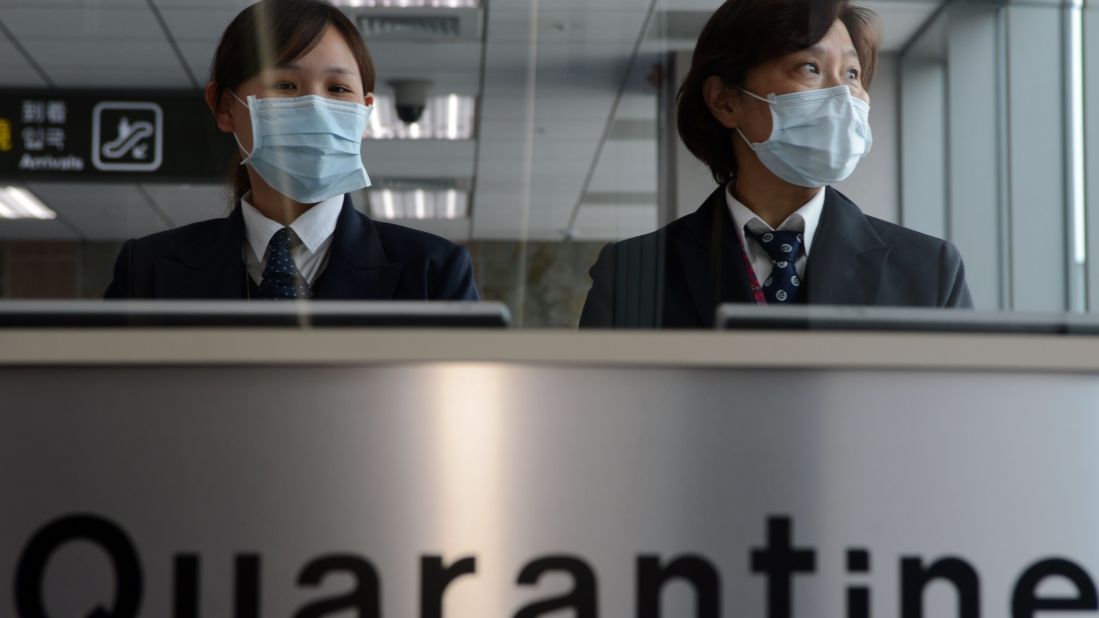 Staff members from Taiwan's Center for Disease Control stand at the entrance of Sungshan Airport in Taipei.