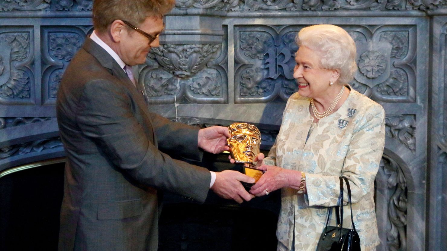 Queen Elizabeth II receives an honorary Bafta from actor and director Kenneth Branagh in recognition of a lifetime's support of British film and television on April 4, 2013.