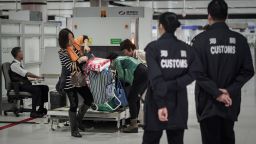 Customs officers monitor baggage checking at a border crossing point with mainland China in Hong Kong on March 1, 2013.