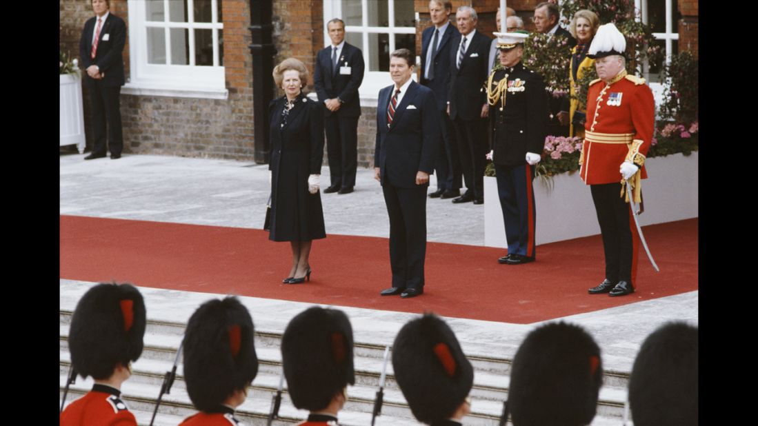 Thatcher and Reagan listen to the American national anthem at Kensington Palace Gardens after Reagan's arrival from Ireland for a summit in London in June 1984.