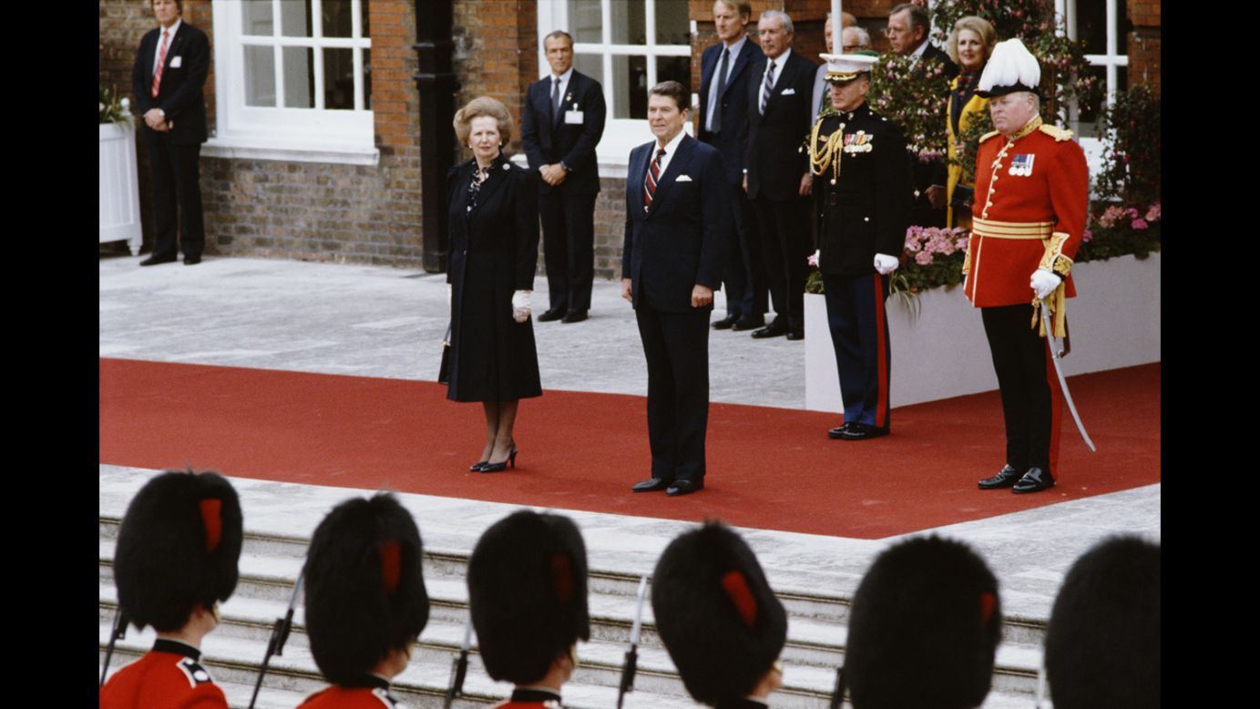Thatcher and Reagan listen to the American national anthem at Kensington Palace Gardens after Reagan's arrival from Ireland for a summit in London in June 1984.