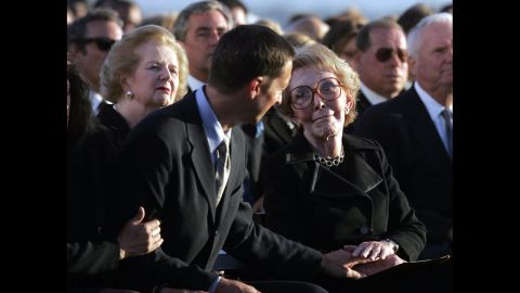 Thatcher sits behind Ronald Prescott Reagan as he comforts his mother, Nancy Reagan, during the late president's interment ceremony in Simi Valley, California, in June 2004.  