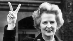 November 1976: Conservative party leader Margaret Thatcher makes a 'victory' sign outside her home in Chelsea, London. 
