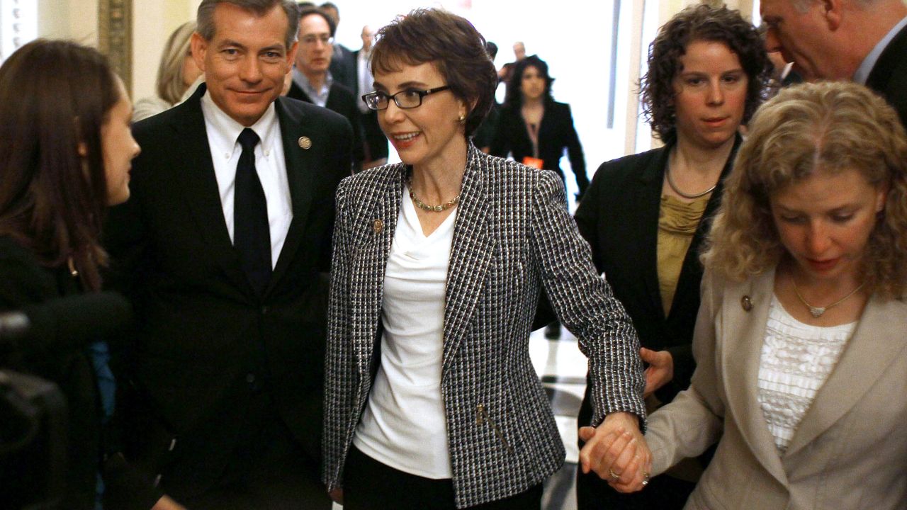 After resigning from Congress, Giffords is escorted down the hall by Rep. Debbie Wasserman Schultz of Florida on January 25, 2012. Giffords left office to focus on her recovery.