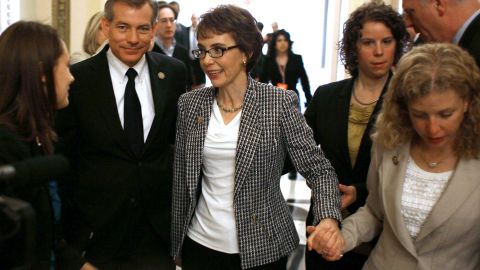 After resigning from Congress, Giffords is escorted down the hall by Rep. Debbie Wasserman Schultz of Florida on January 25, 2012. Giffords left office to focus on her recovery.