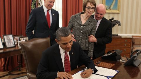 President Obama signs the Ultralight Aircraft Smuggling Prevention Act as Vice President Joe Biden, Giffords and her husband look on in the Oval Office of the White House on February 10, 2012. The bill was the last piece of legislation Giffords voted on before she resigned.