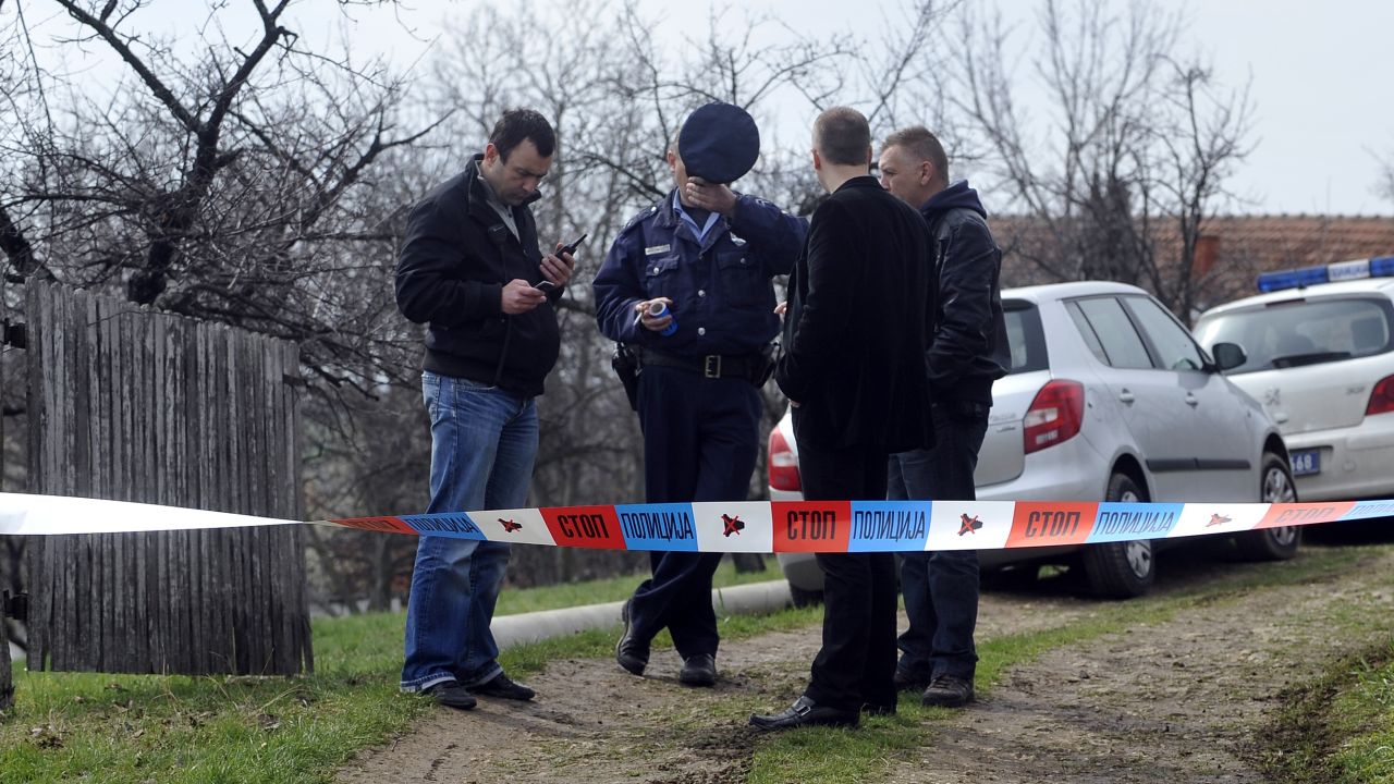Serbian police officers guard the entrance to a yard in the village of Velika Ivanca on Tuesday.