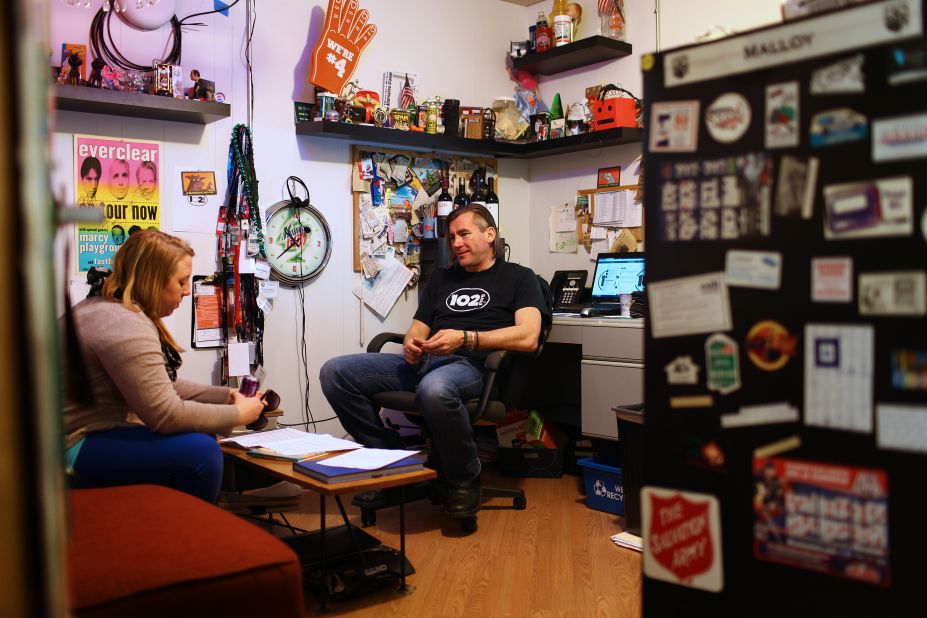 Randy Malloy, CD102.5's president and general manager, chats with marketing director Kara Jones in his office. The station, which isn't part of a larger media corporation, has been independently owned and operated for more than two decades.