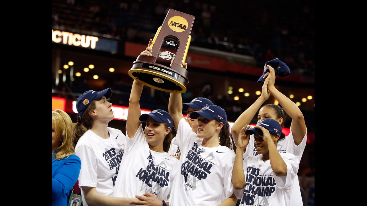 UCONN players hold up the National Championship trophy with their teammates after defeating the Louisville Cardinals on April 9.