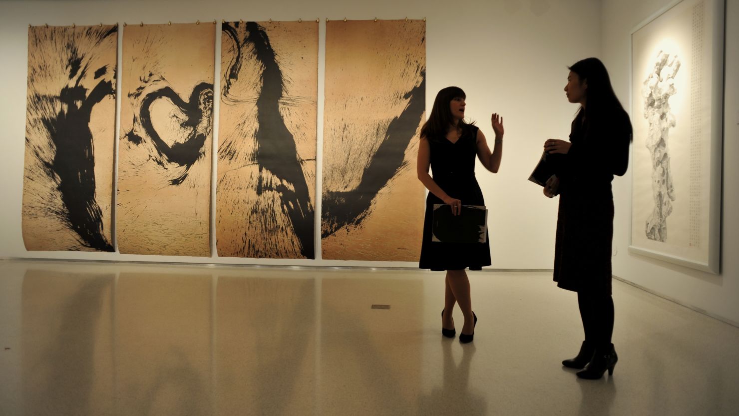 Christie's employees stand in front of a Chinese contemporary ink painting exhibition on February 27 in New York. 