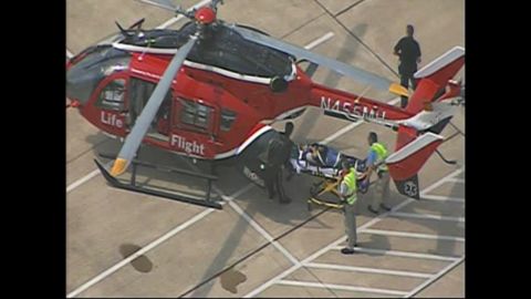 A victim is loaded onto a helicopter.