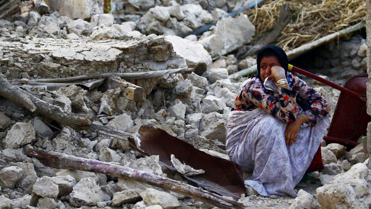 A woman sits among the wreckage in Shanbeh in Bushehr province on April 9.