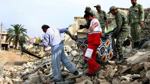 Iranian soldiers and aid workers help a man carry his belongings from his house in Shanbeh on Wednesday, April 10, after a powerful earthquake destroyed it. The magnitude-6.3 quake struck southern Iran on Tuesday, April 9, killing at least 37 people, Iranian state-run media reported. The temblor was centered more than 60 miles southeast of the Bushehr nuclear plant, but Iran's Press TV said the single-reactor facility was undamaged.