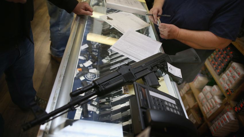  A customer purchases an AK-47 style rifle for about $1200 at Freddie Bear Sports sporting goods store on December 17, 2012 in Tinley Park, Illinois.