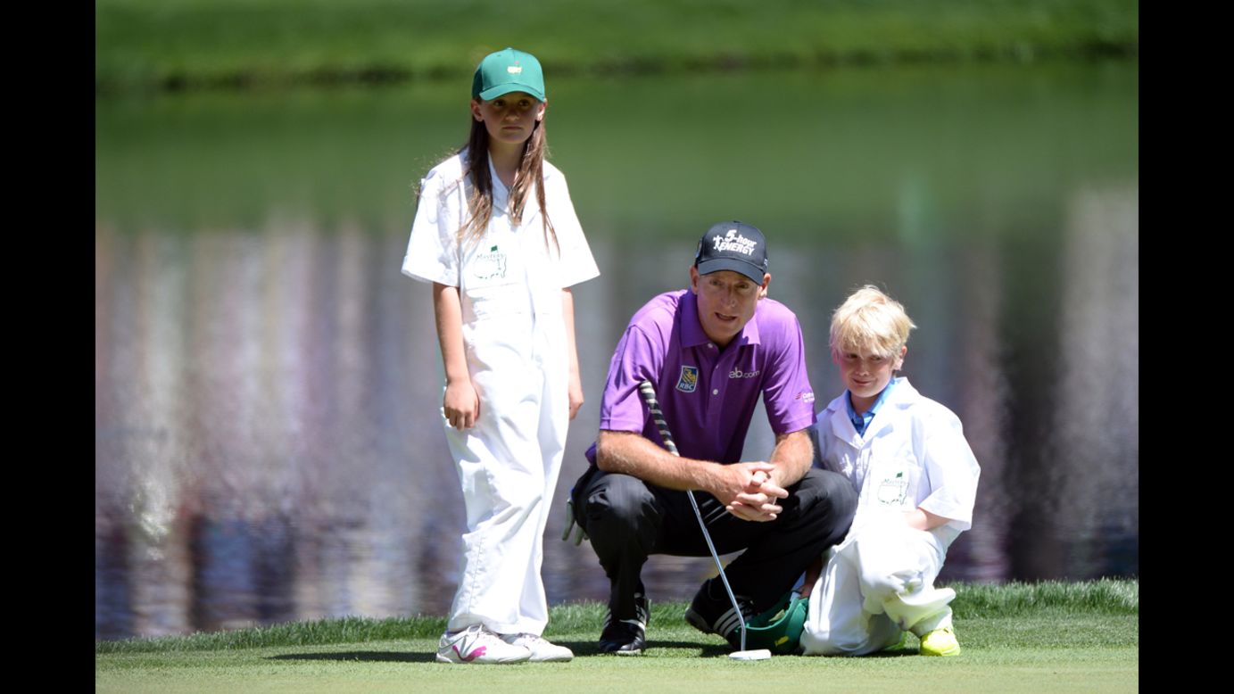 Jim Furyk of the U.S. lines up a putt with his children Caleigh and Tanner.