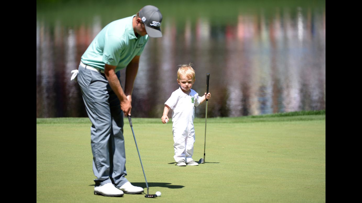 John Merrick of the U.S. putts as his son, Chase, watches.