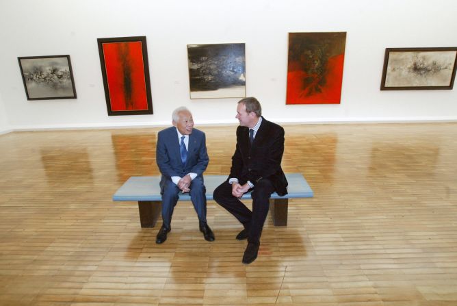 Zao Wou-Ki (L) sits with French Culture Minister Jean-Jacques Aillagon on October 13, 2003, during a press preview of his paintings at the Jeu de Paume Museum in Paris.