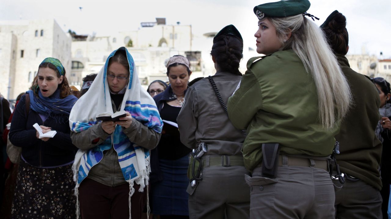 An Israeli border policewoman stands guard as members of the liberal religious group "Women of the Wall" wear tallits, Jewish prayer shawls worn by men, while praying at the Western Wall in Jerusalem's Old City.