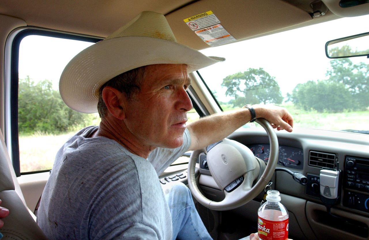 President George W. Bush dresses for the location as he drives his pickup at his ranch in Crawford, Texas, in 2002.
