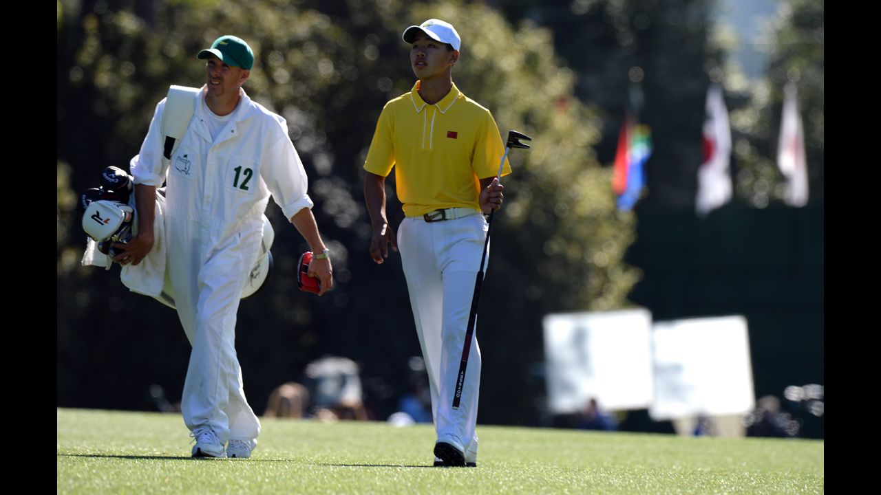 Guan Tianlang of China walks with his caddie during the third round.