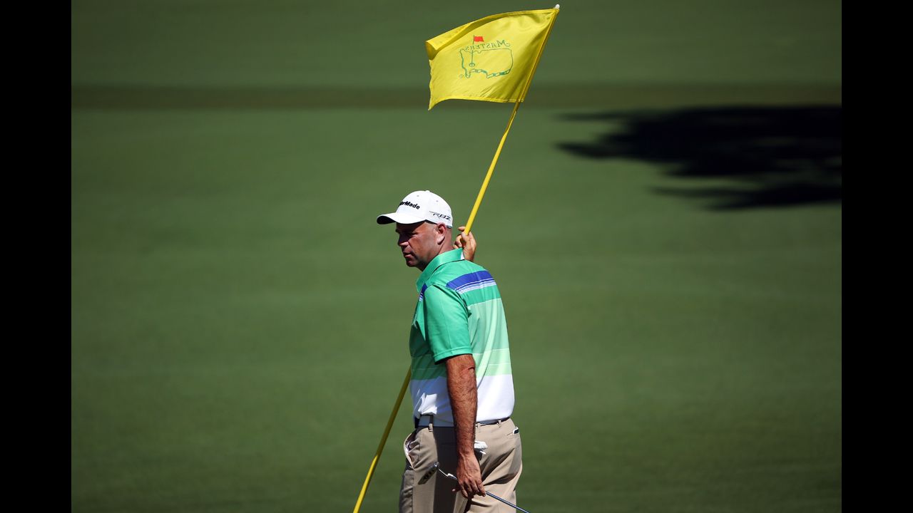 Stewart Cink of the U.S. holds the flag on the second hole.