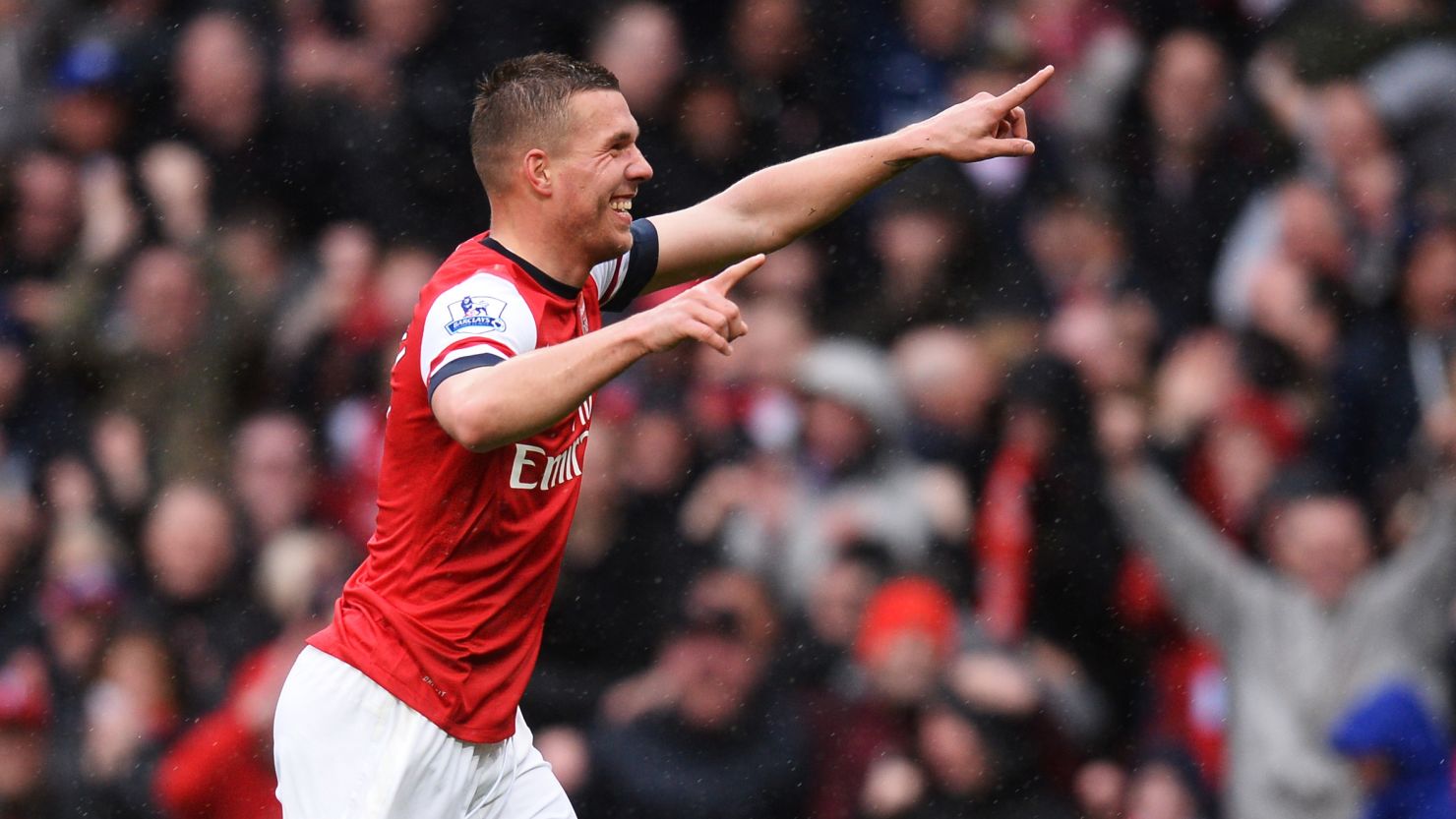Lukas Podolski celebrates scoring Arsenal's third goal in the 3-1 over Norwich at the Emirates Stadium.