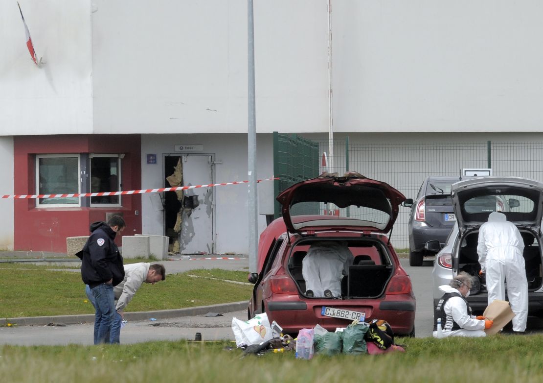 Forensics experts work near a door destroyed by Faid's explosives in 2013.