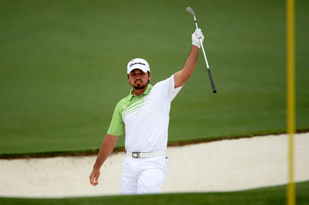 Jason Day of Australia lifts his club after hitting the ball out of the bunker for an eagle on the second hole.