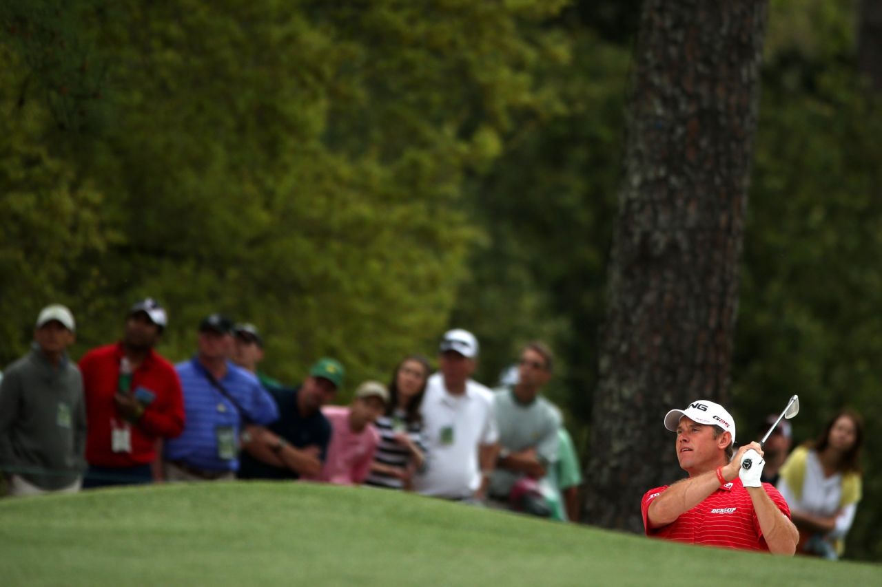 Lee Westwood of England hits a shot on the first hole.