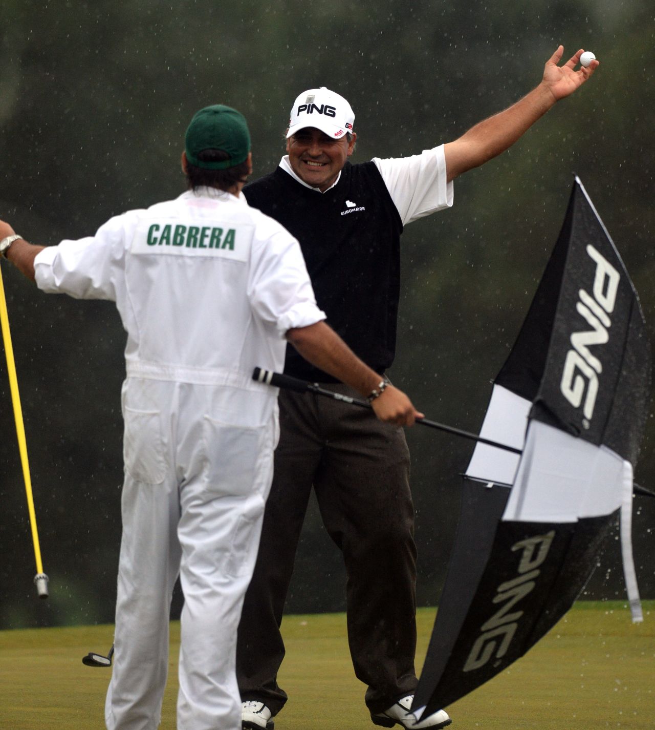 Angel Cabrera of Argentina smiles to his caddie and son Angel Cabrera Jr. after he sinks a birdie putt on the 18th.