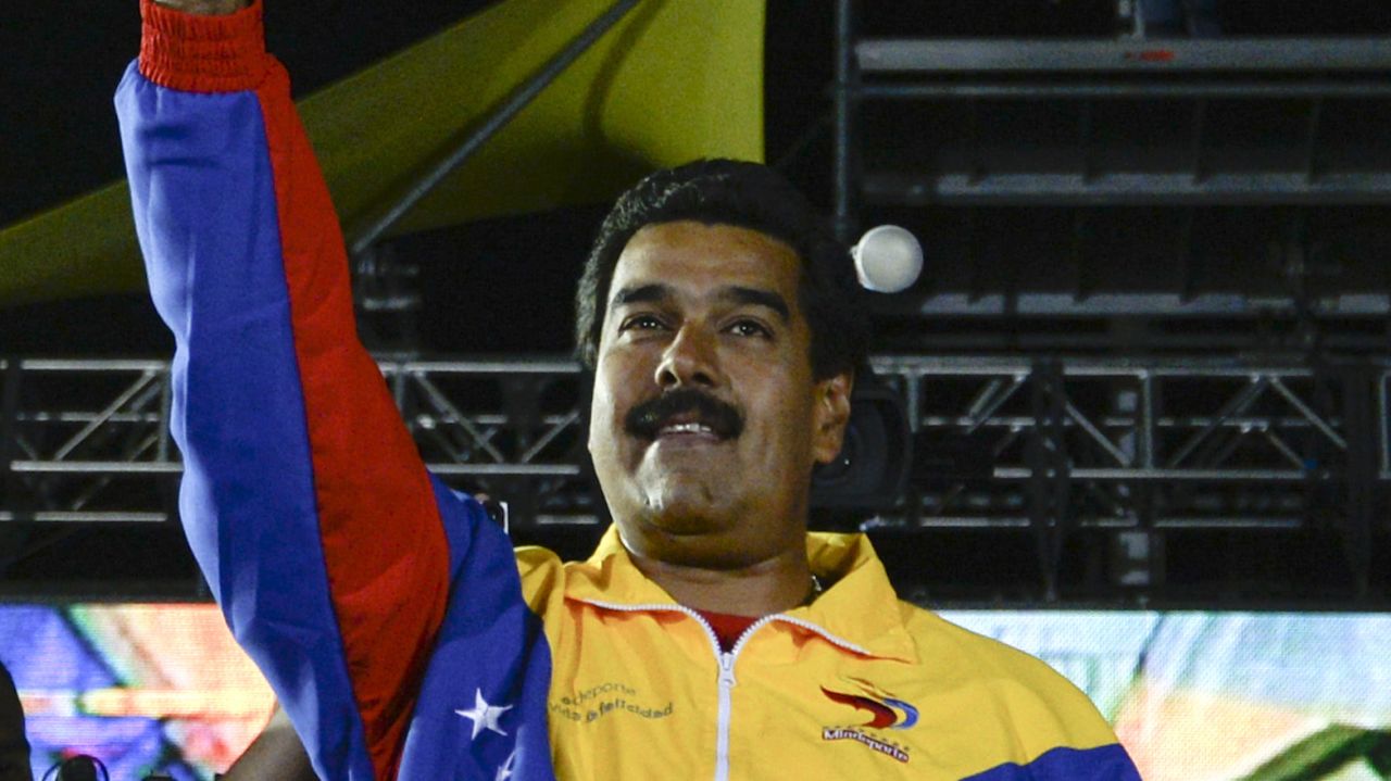 Venezuelan President elect Nicolas Maduro celebrates after knowing the election results in Caracas on April 14, 2013. Venezuela's acting President Nicolas Maduro declared victory on Sunday in the race to succeed late leader Hugo Chavez after the electoral council announced that he had won in a close battle. AFP PHOTO/Juan BARRETO