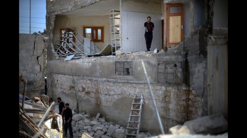 Men inspect damage at a house destroyed in an airstrike in Aleppo on April 15.
