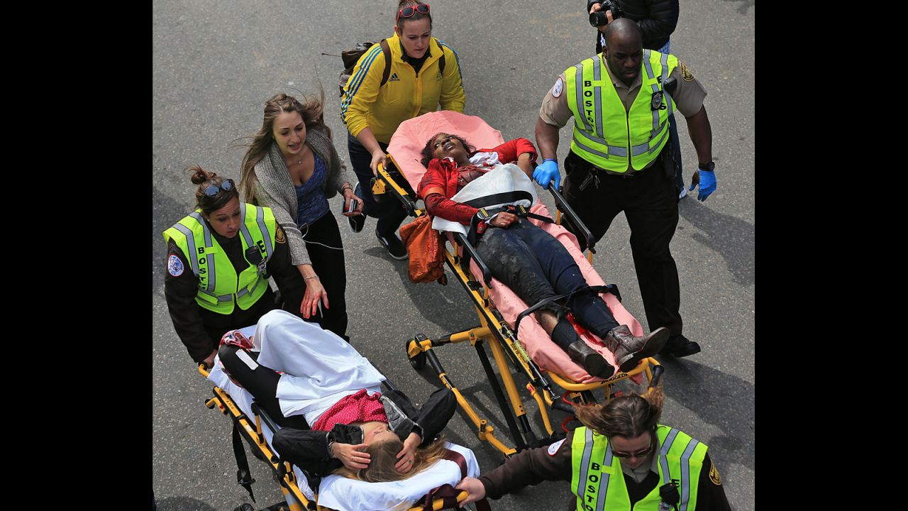 Two injured women are taken away on stretchers.