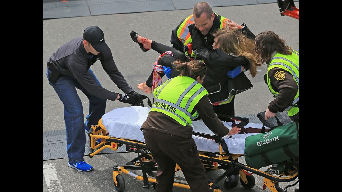 An injured woman is placed on a stretcher. 