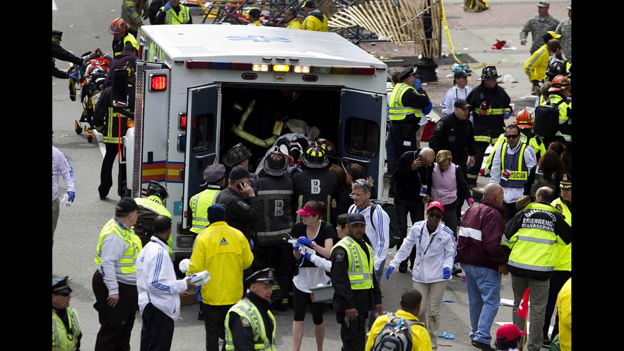 First responders load injured people into an ambulance.