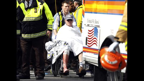 A runner in a wheelchair is taken from a triage tent after the explosions went off.