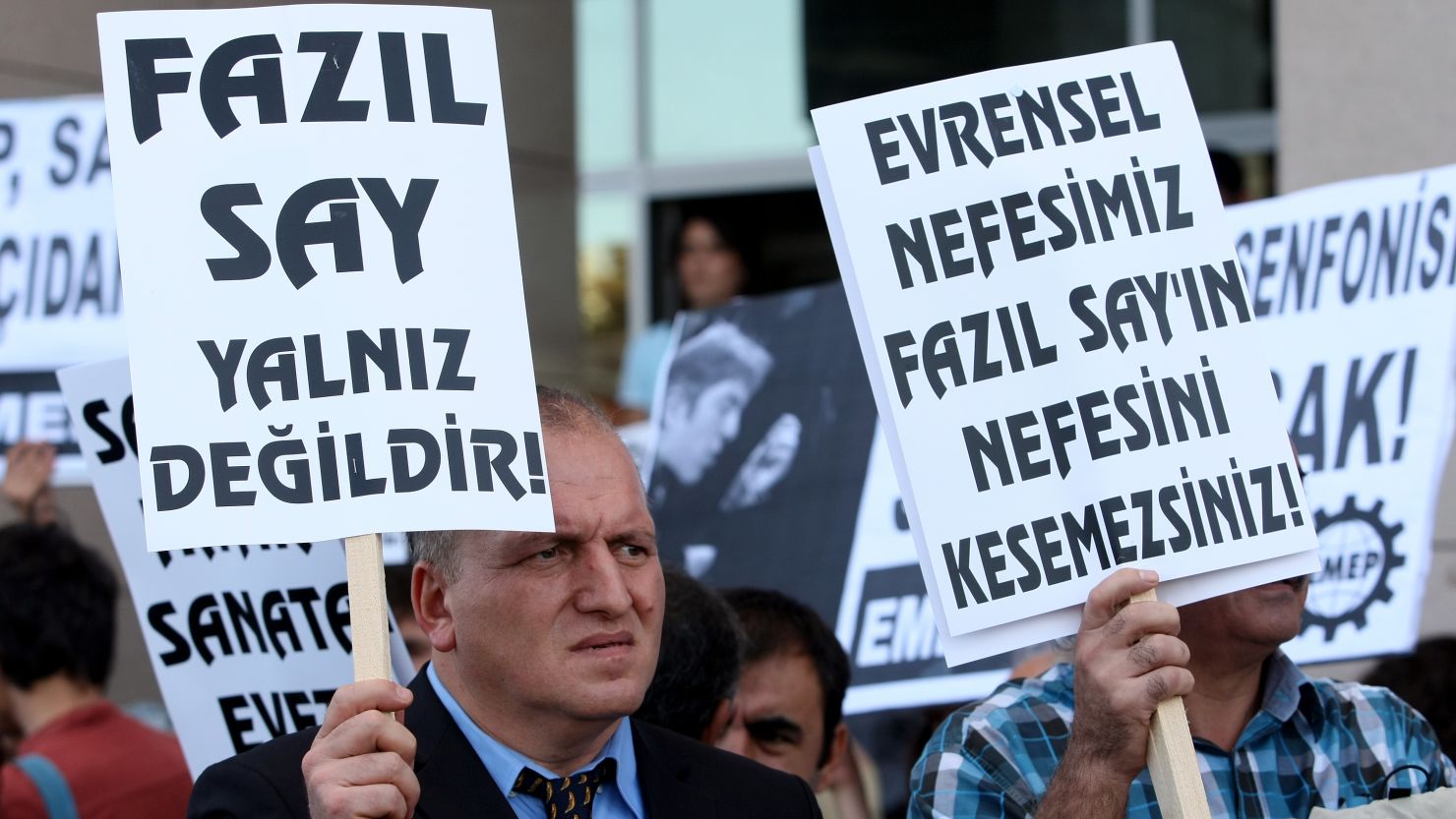 A poster reads "Fazil Say is not alone," left, at a protest outside an Istanbul court on October 18, 2012. 