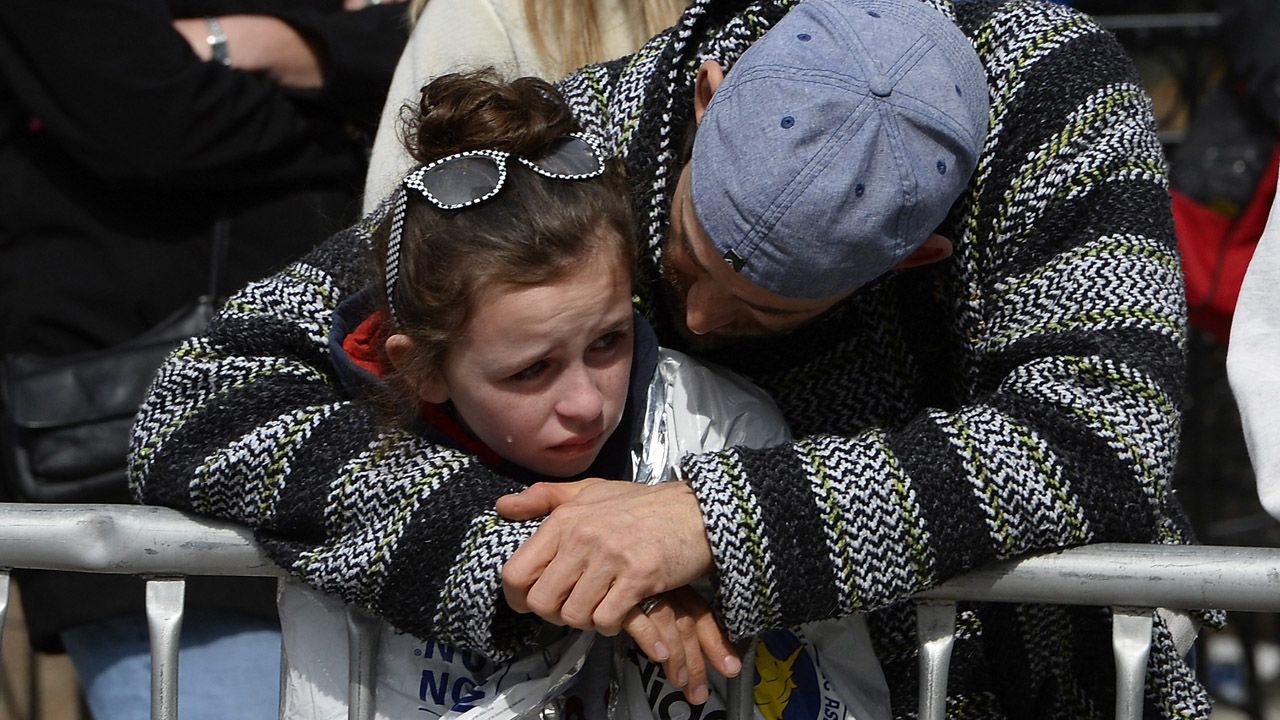 Bystanders embrace near the finish line.