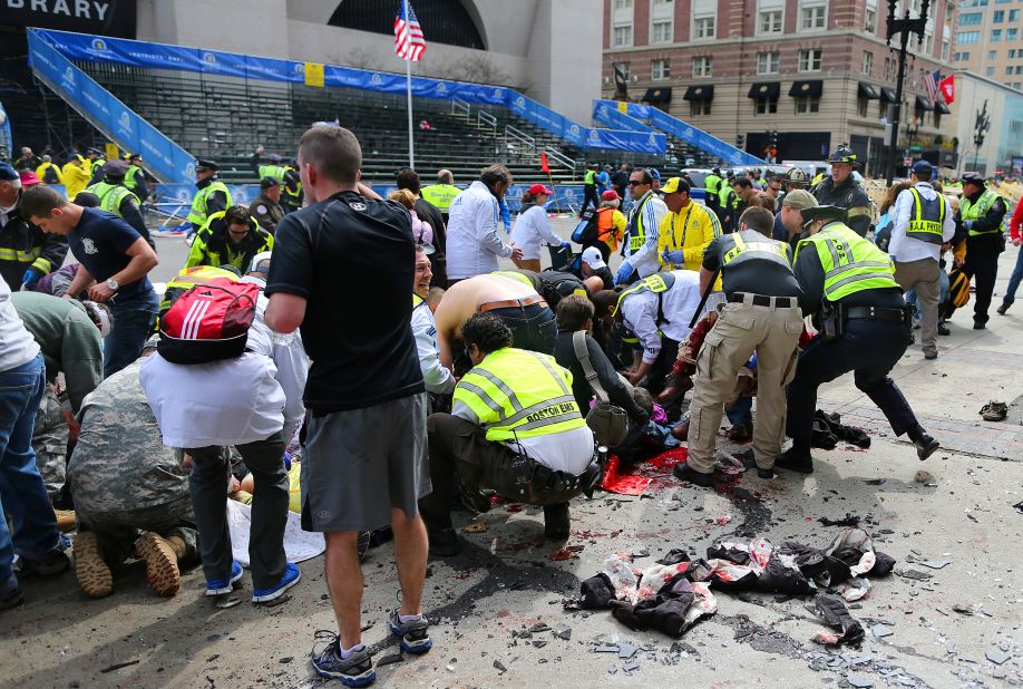 Victims are helped at the scene of the first explosion.