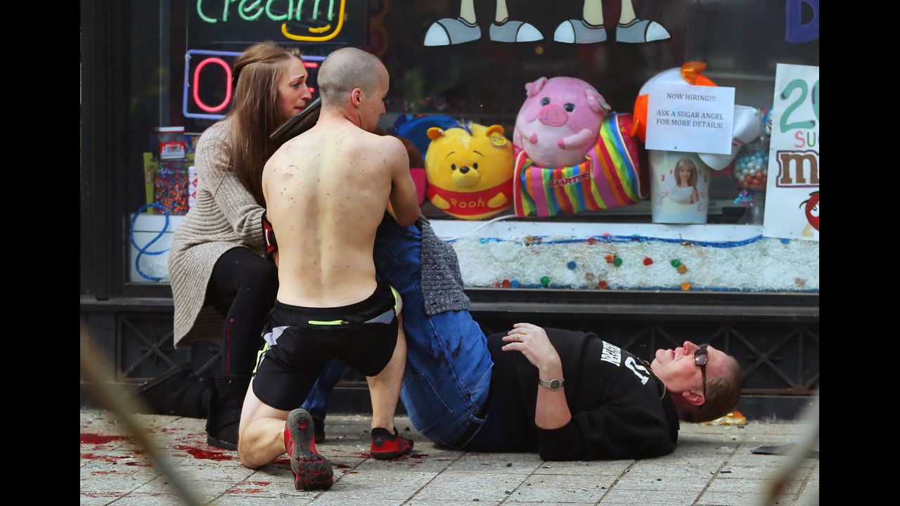 Passersby put pressure on a victim's leg to try to stop the bleeding.