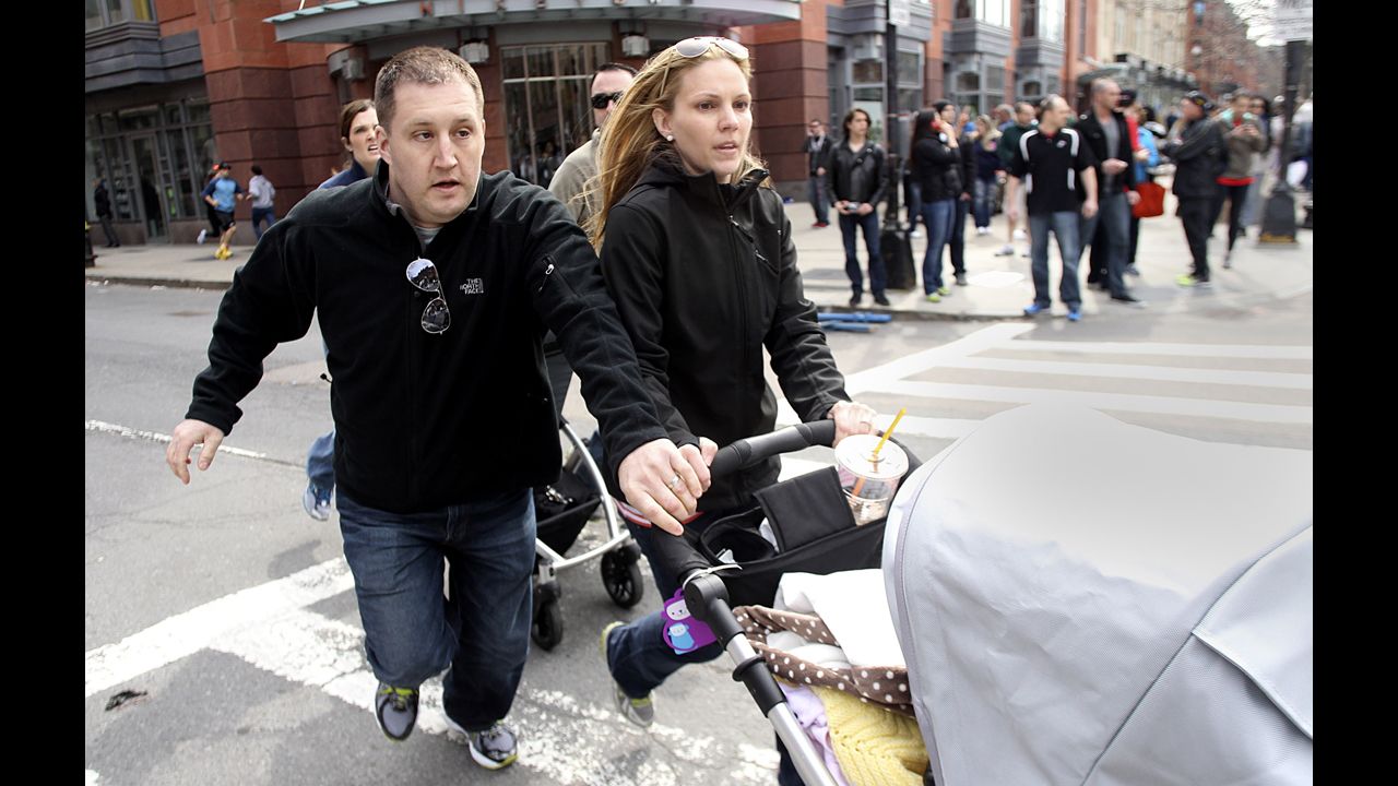 A couple runs from the scene pushing a stroller.