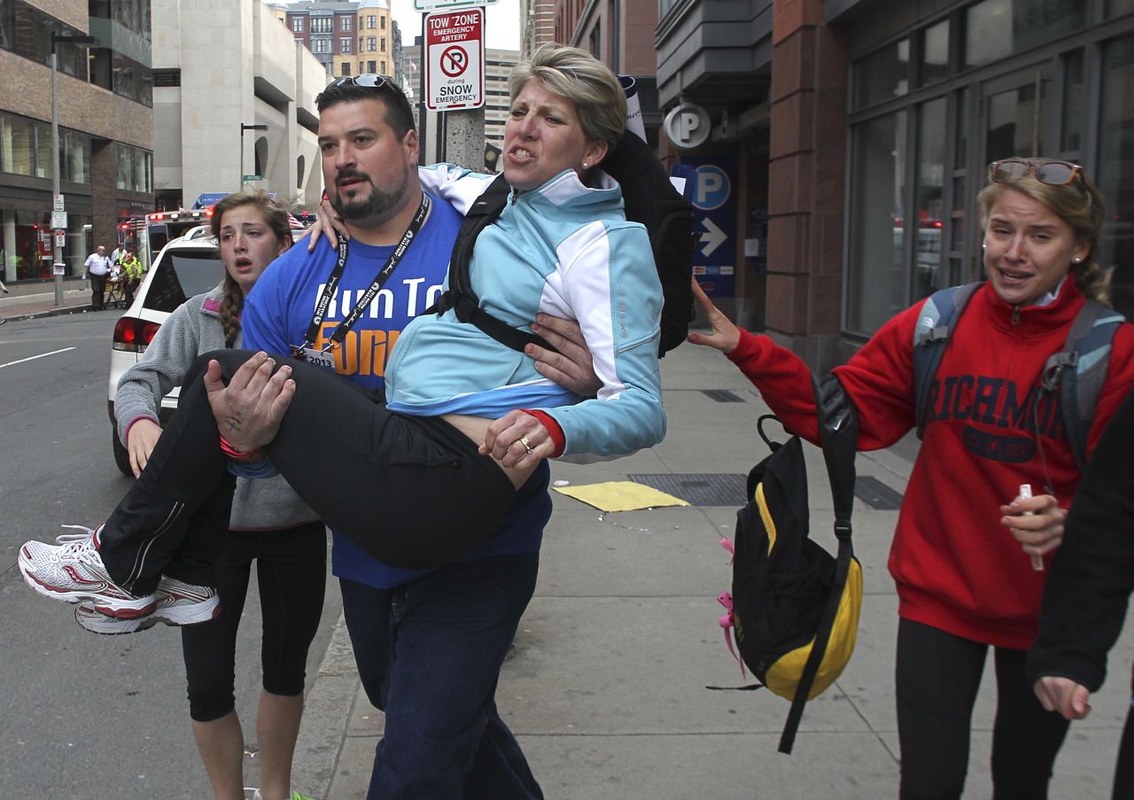 Former New England Patriots <a href="http://bleacherreport.com/articles/1606043-former-new-england-patriot-joe-andruzzi-assists-survivors-at-boston-marathon" target="_blank" target="_blank">offensive lineman Joe Andruzzi</a> carries a woman from the scene.