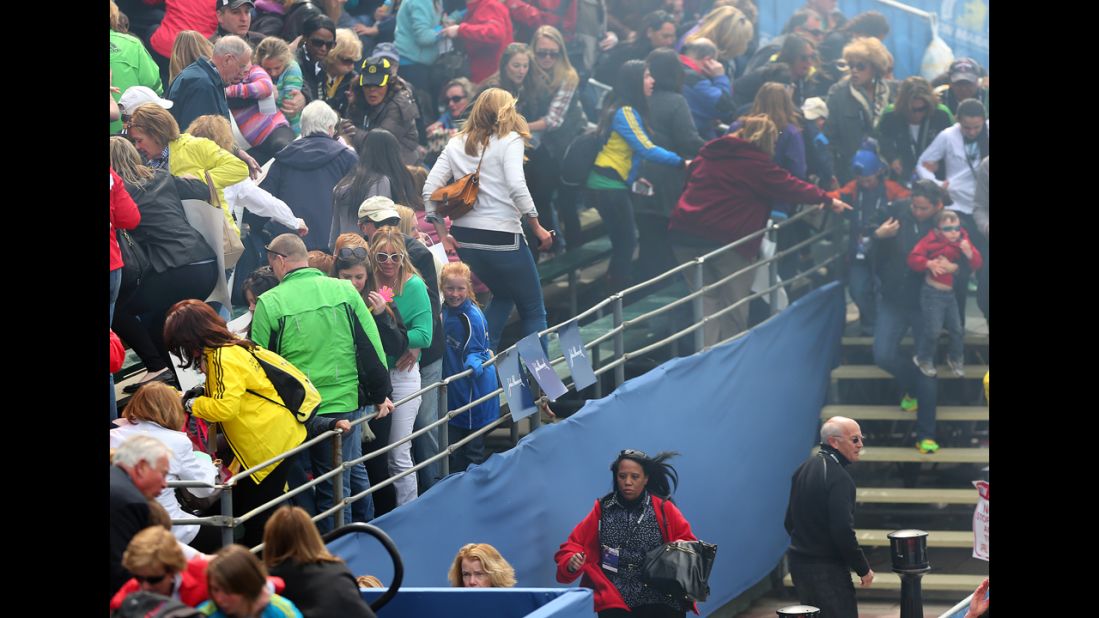 Spectators leave the bleachers after the explosions.